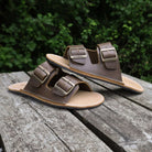 pair of mens brown acacia barefoot sandals outside on a wooden table top