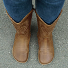 modeal wearing cognac barefoot cowboy boots showing a top down view of the toe shape
