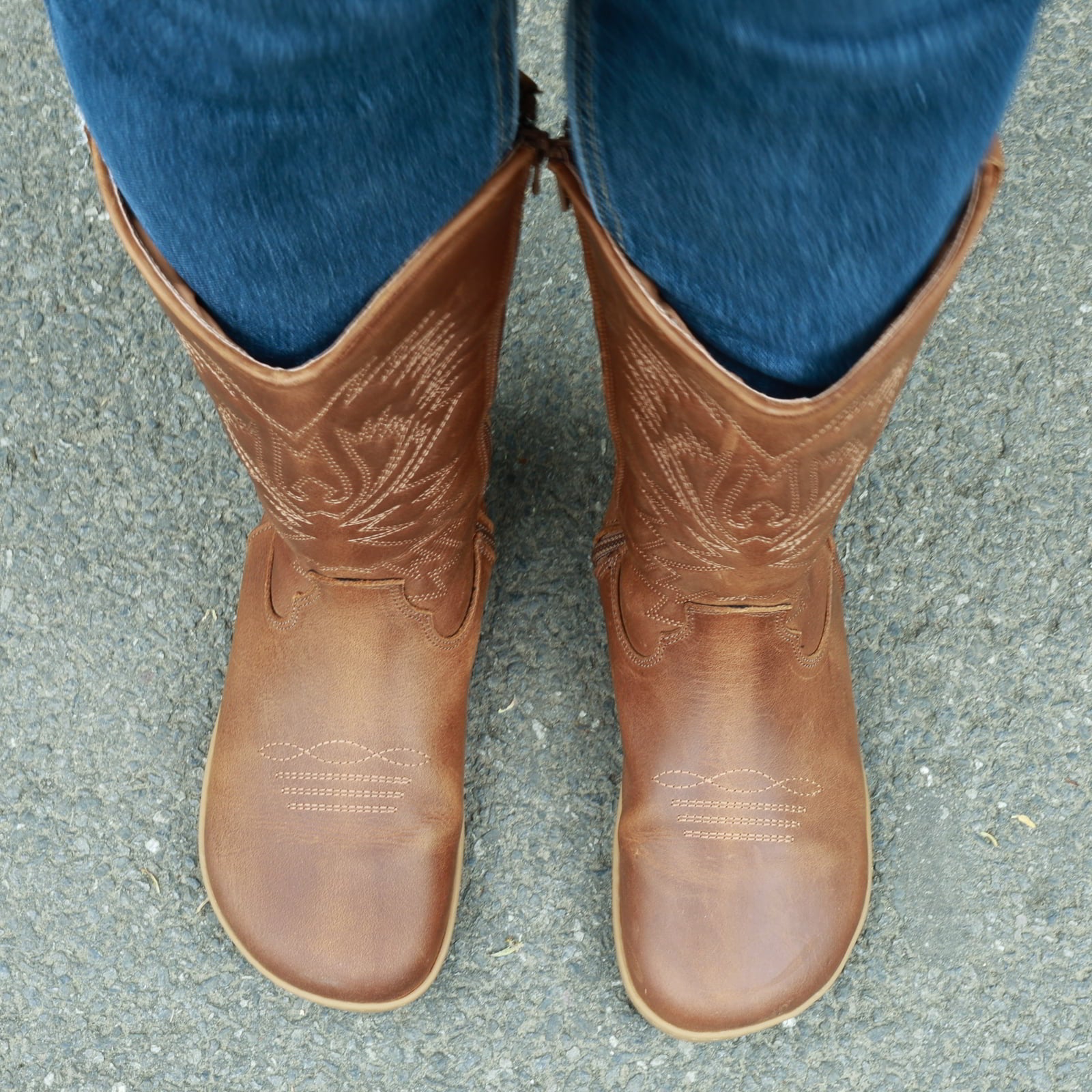 modeal wearing cognac barefoot cowboy boots showing a top down view of the toe shape