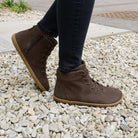 model wearing mulberry barefoot ankle boots in brown standing on a gravel path