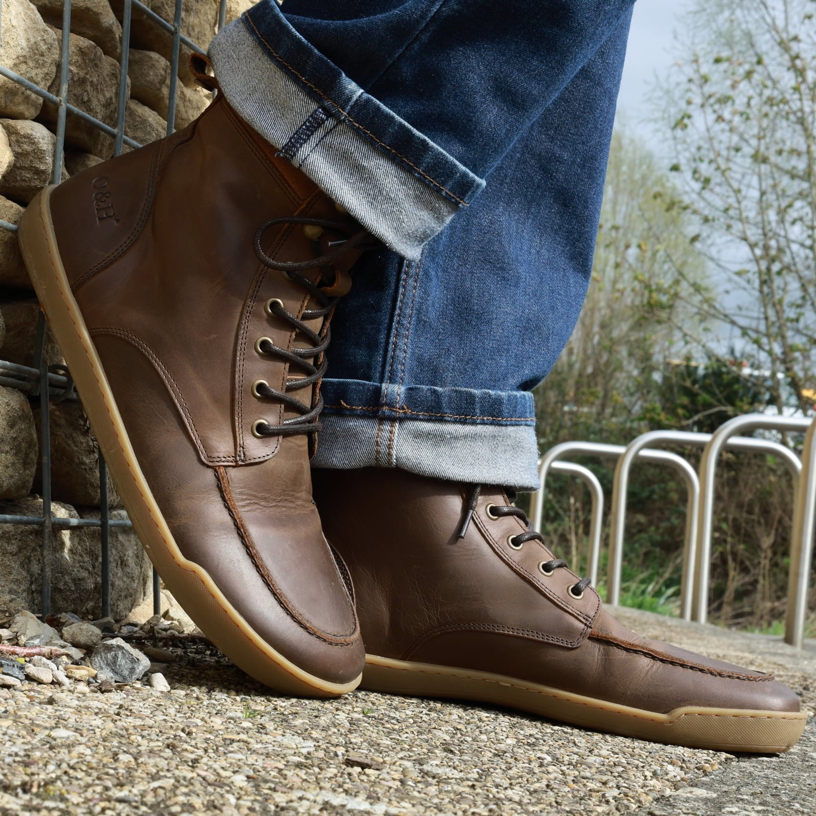 model standing in redwood barefoot boots in dark brown leaning against a wall