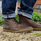 person standing on pebble path wearing redwood dark brown barefoot boots