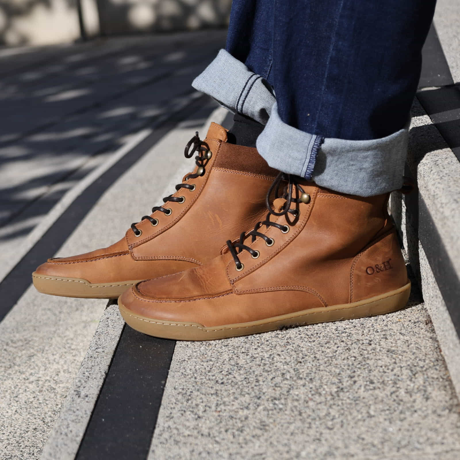 model sitting on step wearing redwood boots in tan with blue jeans