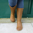 model wearing tan brown barefoot boots showing toe shape on concrete floor