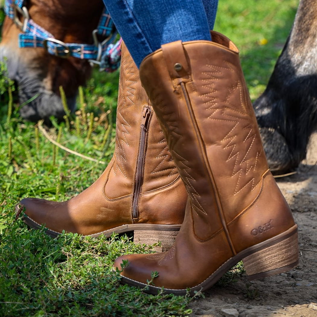 model wearing texan hi cowboy boots in cognac with blue jeans