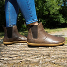 picture taken outdoors of model wearing brown chelsea boots