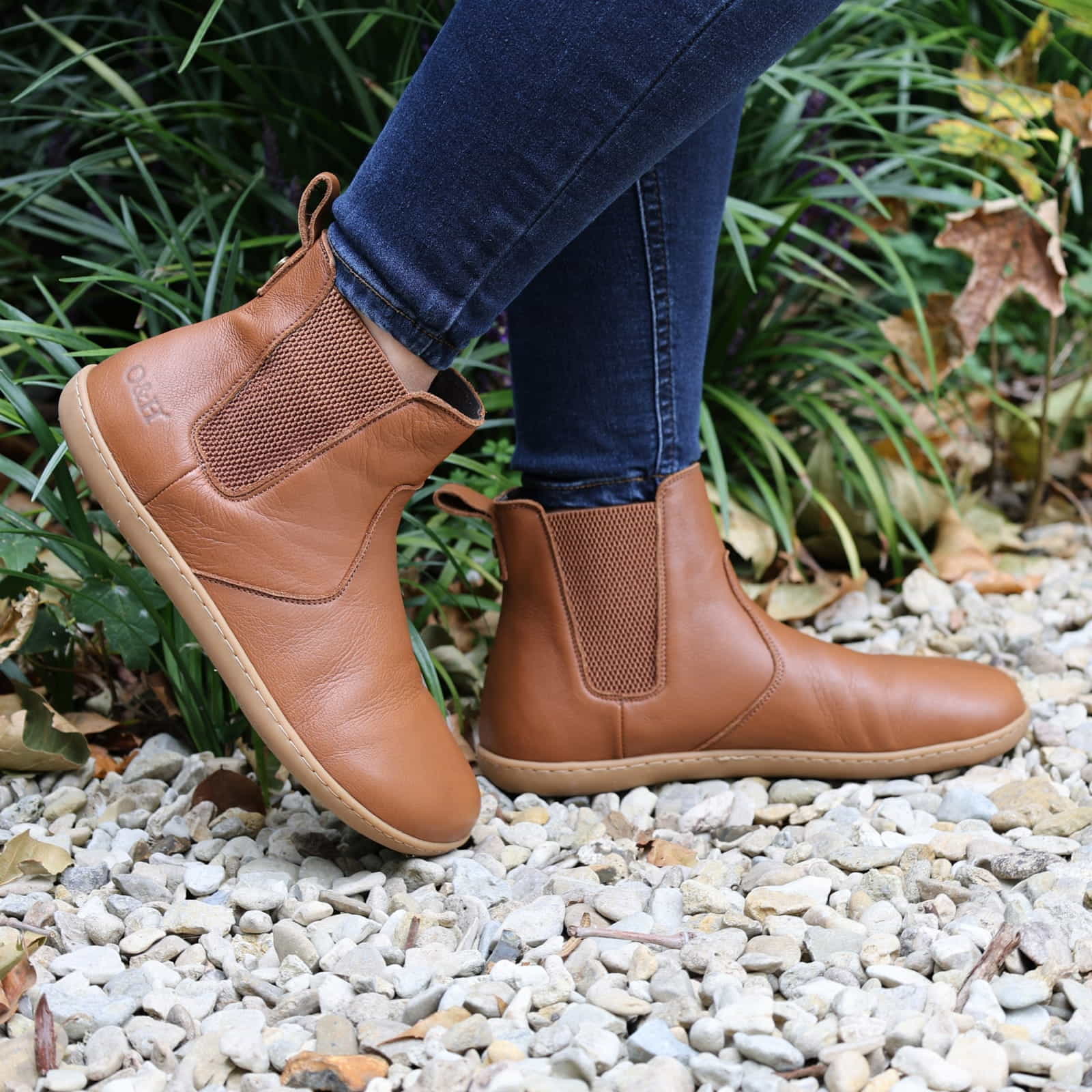 model wearing tan barefoot chelsea boots in an outdoor setting