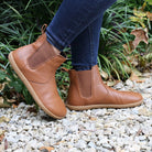 model wearing tan barefoot chelsea boots in an outdoor setting