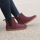 model sitting on bench wearing willow zip barefoot boots with jeans
